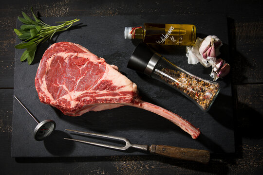 Raw tomahawk steak and ingredients