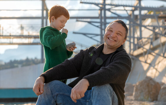 Smiling father and son enjoy spending time at the beach promenade