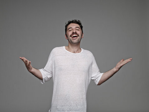 Portrait of arrogant man in front of grey background
