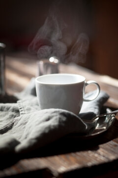 Steaming cup of English black breakfast tea on a silver plate