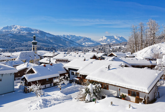Germany, Bavaria, Upper Bavaria, Chiemgau, View to Reit im Winkl in winter, Unterberghorn and Kaiser mountains in the background