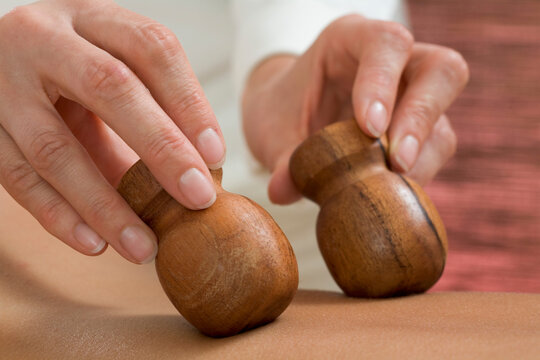 Young woman receiving massage with wooden stamps, close-up