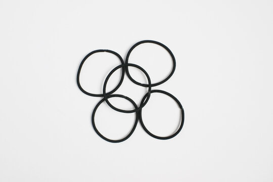 Five Interlocking Black Rubber Rings on White Background