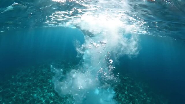 Underwater View of Air Bubbles and Water Splash with Sunlight Rays Penetrating Clear Blue Ocean Surface Over Coral Reef