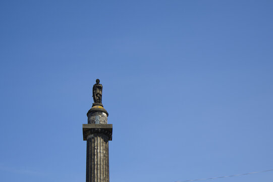 Top of the Melville Monument column with the statue of Henry Dundas against a clear blue sky in St Andrew Square, Edinburgh, Scotland.