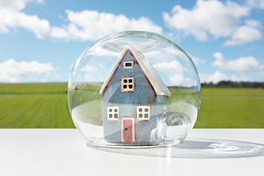 Protect your house insurance, security and home protection concept, glass dome shield protecting model house