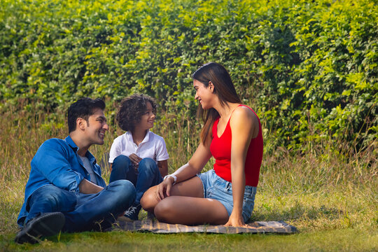 Happy couple with their son spending time in park
