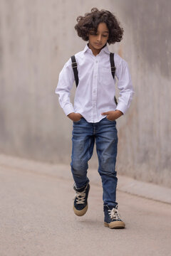 Little boy in school uniform walking down the street to school