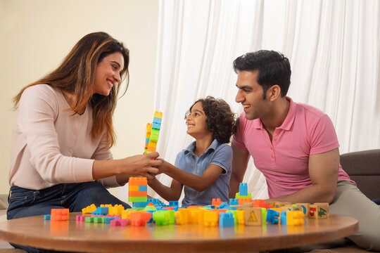 Parent and son playing together with toy blocks 