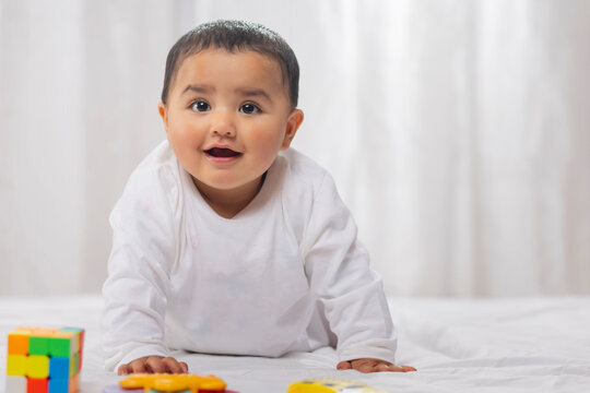 Cute little child crawling on bed alone