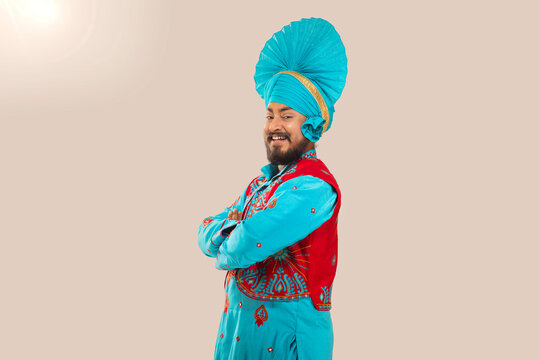 Portrait of happy Sikh man posing in front of camera with arms crossed
