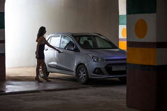 Young woman opening car door at basement parking