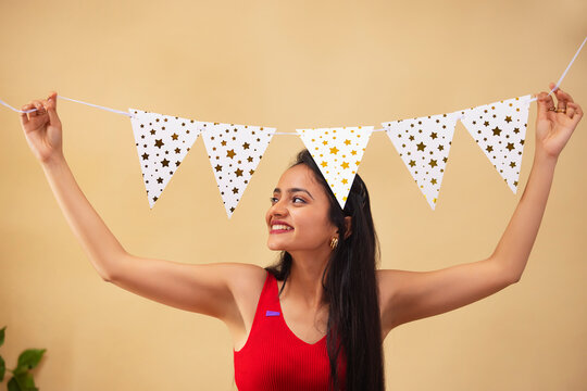 Young woman decorating home with bunting flags