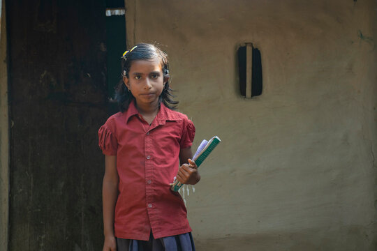 rural girl holding books ready for school. India