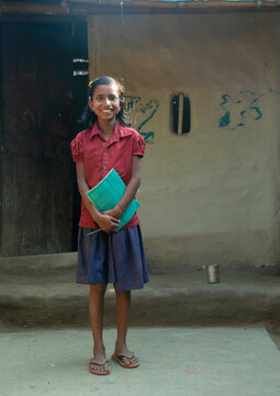 rural girl holding books ready for school. India