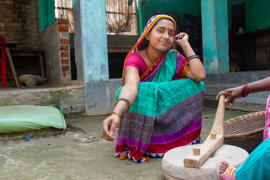Indian woman grinding flour in grinding stone at her house in a village
