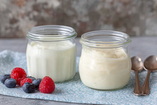 Homemade yogurt in small jars on a table with tablespoons 