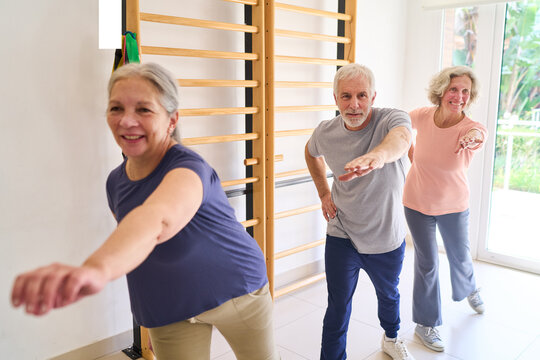 Senior Adults Doing Arm Exercises in Rehabilitation Center Indoor Gym with Physiotherapy Equipment for Recovery and Improved Mobility