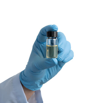 Hand in blue nitrile glove holding a small glass vial with yellow liquid and black cap isolated PNG. The scientific image features a researcher holding a chemical or biological sample.