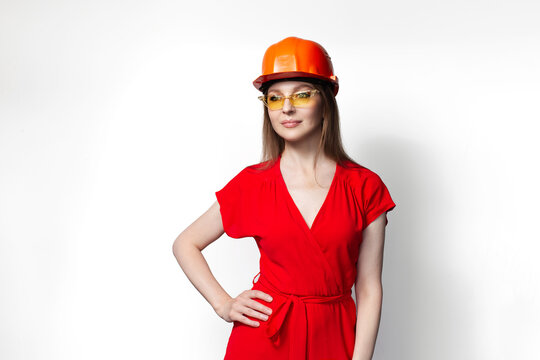 Young girl in red dress wearing safety helmet and sunglasses isolated on white background.