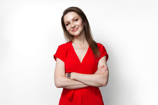 Young smiling girl in red dress with crossed hands isolated on white background.