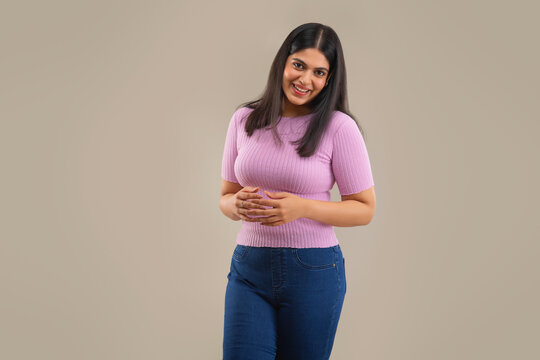 A YOUNG WOMAN CHEERFULLY STANDING IN FRONT OF CAMERA