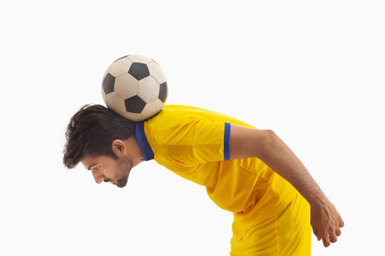 A CONFIDENT PLAYER BALANCING FOOTBALL ON HIS BACK WHILE PRACTICING