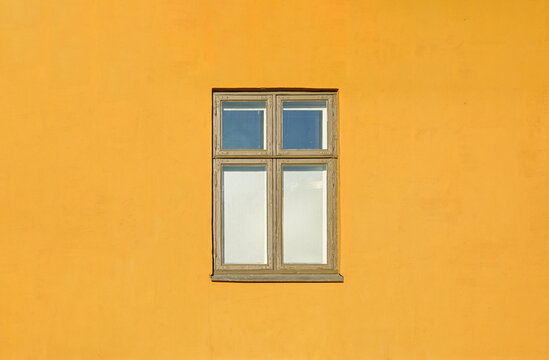 Minimalist facade showing window on yellow wall