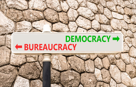 Democracy or bureaucracy words symbol. Concept words Democracy Bureaucracy on beautiful white road sign. Beautiful stone wall background. Business democracy bureaucracy concept. Copy space