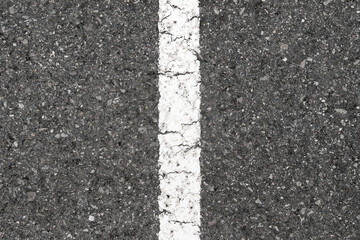 Fototapeta premium Grey asphalt road surface featuring a straight white painted traffic line with weathered cracked paint. Minimalist industrial design texture