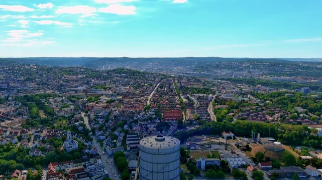 Aerial drone view of Stuttgart with the Gaisburg gasometer in the foreground, Stuttgart East residential districts, the city basin and wooded hills, Baden Wurttemberg, Germany, in summer.