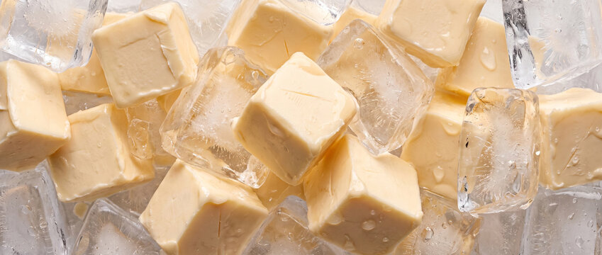 Yellow butter cubes stored on ice chunks horizontal view