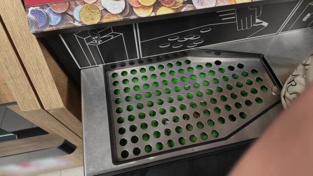 Woman Depositing Coins Into a Coin Counting Machine Outdoors