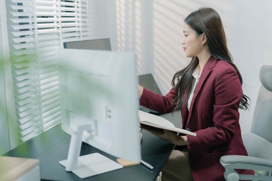 A businesswoman is analyzing stock trading charts on a computer screen in an office; the image shows a female investor analyzing data and working with the cryptocurrency exchange market.