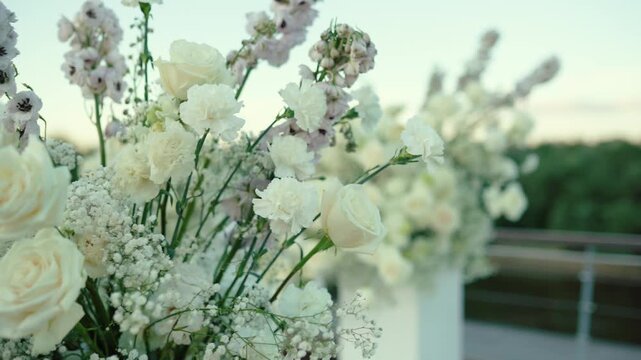 wedding arch of white rose flowers on the river bank before the wedding ceremony of the bride and groom, festive romantic decor