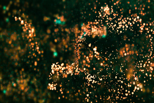 Close-up of glowing orange light particles on dark background