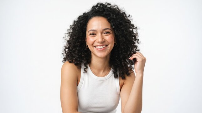 Beautiful young woman with curly hair smiling brightly against a plain white background