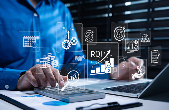 Analyzing ROI and Business Strategy Concepts. Businessman working on laptop with various digital icons representing ROI, financial strategies, marketing plan, return on investment and efficiency.
