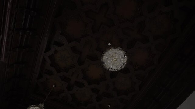 Ornate coffered ceiling with suspended crystal chandeliers in historic interior, with chandelier, ceiling, coffer, wood detail, showing molding, ornate, crystal, fixture context