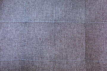Fototapeta premium Close up of grey woven upholstery fabric with stitched square seams, ideal for interior design, furniture and textile background content with copy space.