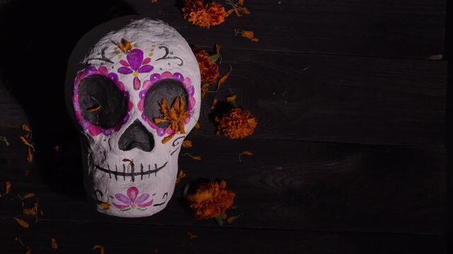 Decorative sugar skull calavera with purple florals on wood for Day of the Dead celebration