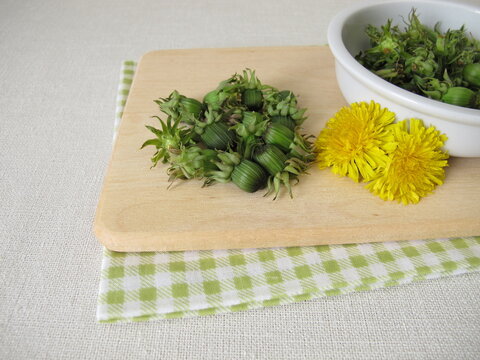 Fresh dandelion buds from the meadow on a wooden cutting board