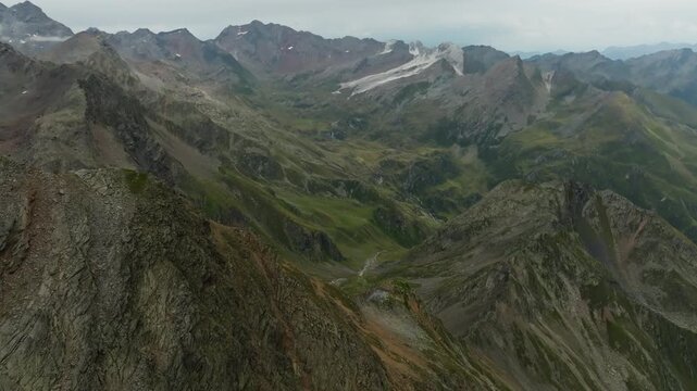 Drone aerial footage of Timmelsjoch mountain pass across the Austria Italy border surrounded by majestic Tyrol Alps rocky peaks untouched nature and scenic travel destination