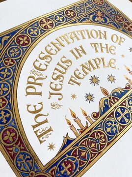 Close up of an illuminated medieval manuscript page with ornate blue and gold floral border, decorative lettering, and religious symbolism. Historic calligraphy and sacred art concept.