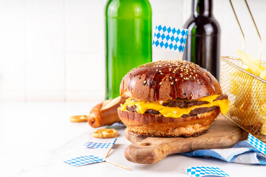 Oktoberfest Burger menu with french fries, pretzels, beer bottles. Tasty cheese hamburger in pretzel bun, with french fries, bavarian beer snacks, with checkered tablecloth and Oktoberfest decor