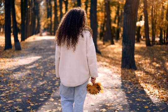 Woman walking through an autumn park.