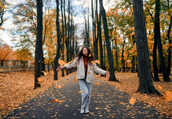 Fototapeta premium Smiling woman enjoying an autumn walk in the park.