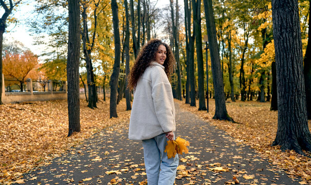 Young woman walking through an autumn park.