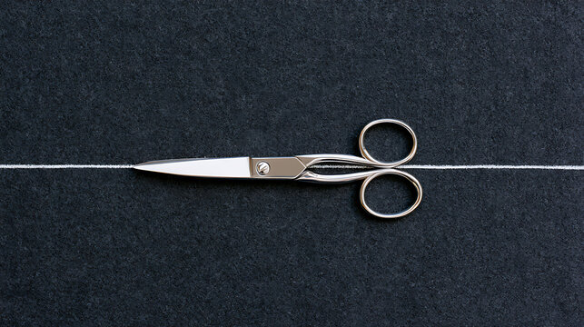 Metal scissors cut white thread on dark fabric background, top view flat lay composition representing precision, craft, and tailoring art