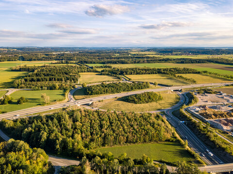 Aerial view of highway interchange roundabout surrounded by green fields and forest near Landsberg am Lech, Bavaria